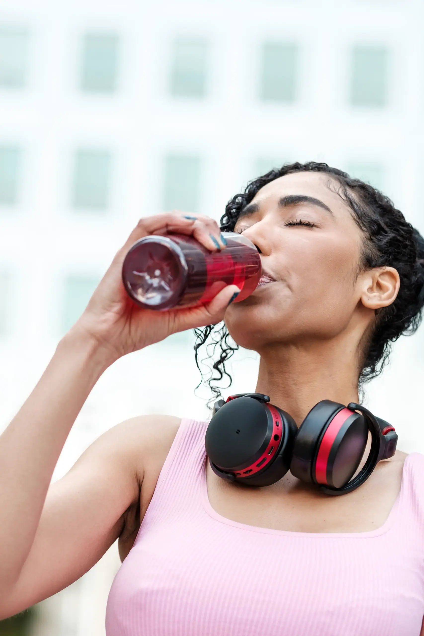 portrait-of-fitness-woman-with-headphones-drinking-2024-07-10-04-05-43-utc